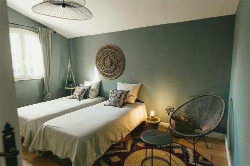 - une chambre avec 2 lits, une table et un ventilateur dans l'établissement Villa des Baumes, à Cornillon-Confoux