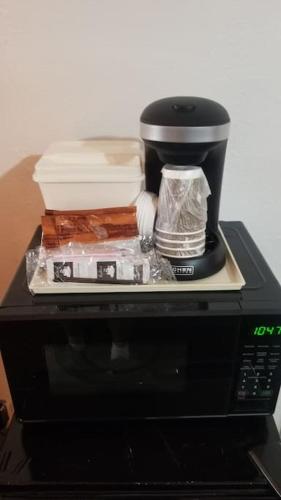 a coffee maker sitting on top of a microwave at OSU Queen Bed Hotel Room 217 Wi-Fi in Stillwater