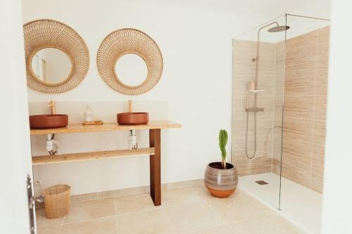 La salle de bains est pourvue de deux miroirs, d'un lavabo et d'une douche. dans l'établissement Villa des Baumes, à Cornillon-Confoux