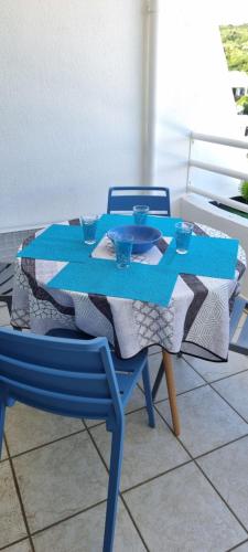 einem blauen Tisch mit 2 Stühlen und einem blauen Tischtuch in der Unterkunft Appartement 1 pièce Saint-Gilles-Les-Bains in Saint-Gilles-les-Bains