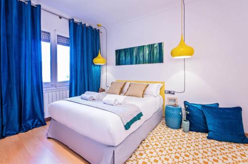 バルセロナにあるSweet Inn - Vicky Barcelonaのベッドルーム(青いカーテン付きの白い大型ベッド1台付)