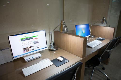 a desk with a computer monitor and a keyboard and mouse at Summit Hotel Seoul Dongdaemun in Seoul