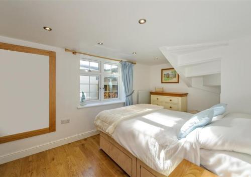 een slaapkamer met twee bedden en een raam bij Jennys Cottage in Abersoch