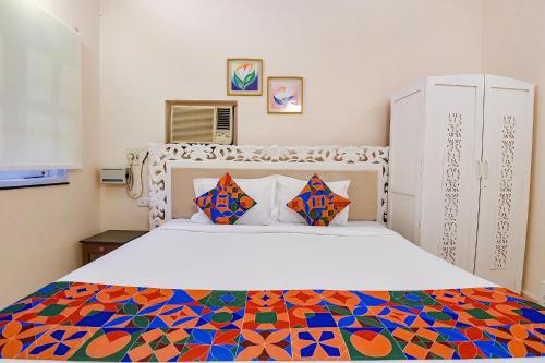 um quarto com uma cama grande e uma colcha colorida em FabHotel Prime Pool Point Highland, Candolim Beach em Candolim