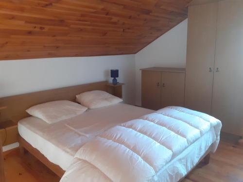 Cama grande en habitación con techo de madera en Cantalaoude en Soulac-sur-Mer