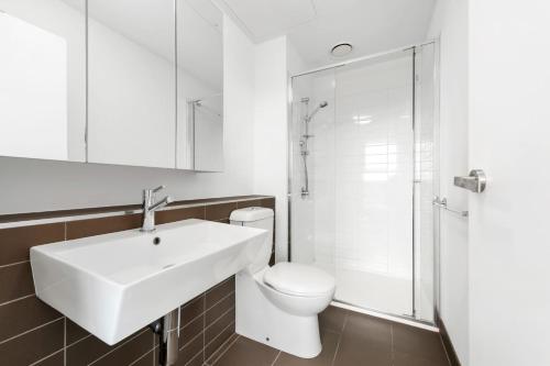 a bathroom with a sink and a toilet and a shower at Sakura Apartment in Melbourne