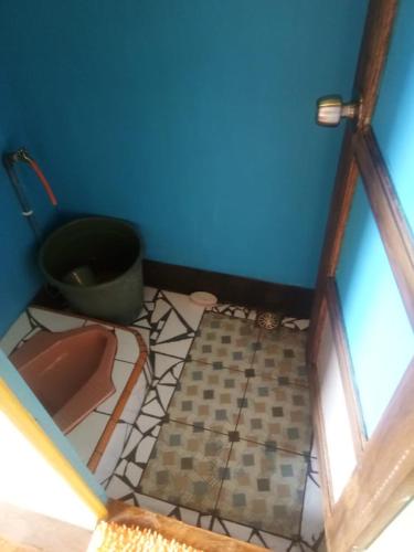 a bathroom with a toilet and a blue wall at Bamboo Park & Resort Malino in Malino