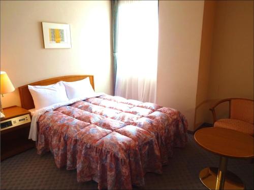 a hotel room with a bed and a window at Shingu UI Hotel in Shingu