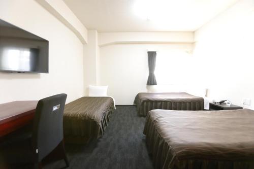 大阪市にある大阪コロナホテルのベッド2台、薄型テレビが備わるホテルルームです。
