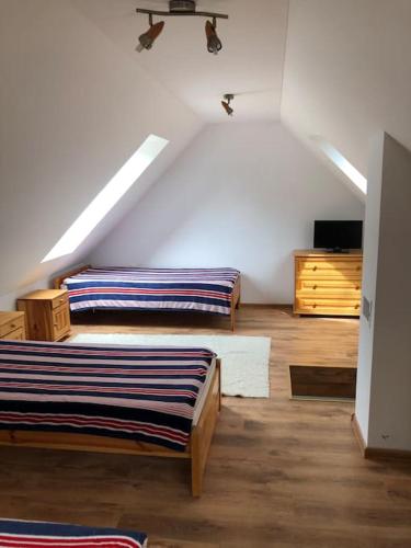 a attic room with two beds and a dresser at CHATA ORAVSKA PRIEHRADA in Námestovo