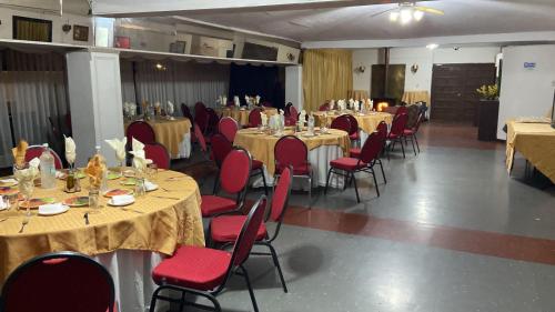 a banquet hall with tables and red chairs at NEW HOTEL CRUZ DEL SUR in Concepción