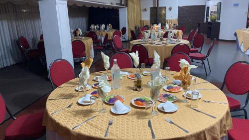 a table with plates of food on it with red chairs at NEW HOTEL CRUZ DEL SUR in Concepción