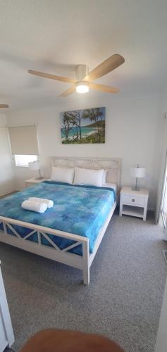 1 dormitorio con 1 cama grande y ventilador de techo en Pandanus Coolum Beach, en Coolum Beach
