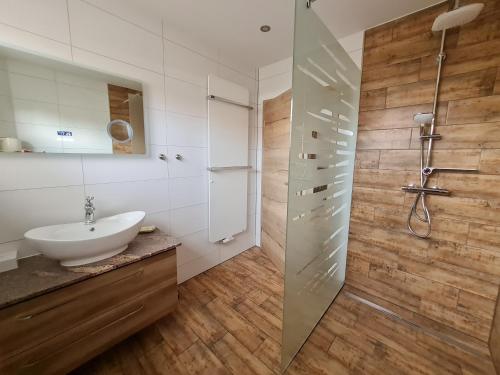 y baño con lavabo y cabina de ducha acristalada. en Ferienwohnung Jekarie en Weimar