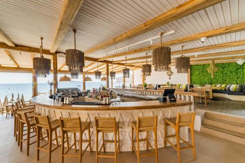 a bar in a restaurant with chairs and tables at Skiathos Theros, Philian Hotels and Resorts in Skiathos Town