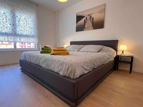 a bedroom with a bed with two yellow towels on it at Apartamento Aguanaz 1 in Entrambasaguas