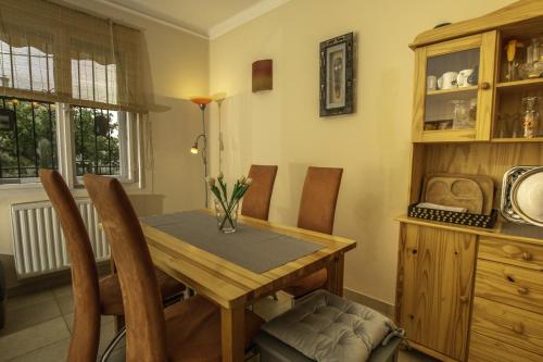 a dining room with a wooden table and chairs at Diófa Apartman Balatonederics in Balatonederics