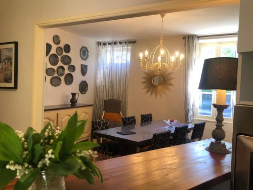 une salle à manger avec une table et un lustre dans l'établissement Le Clos des Lys, Maison de Pays Raffinée Proche de la Mer, Linge Inclus, à Saint-Georges-dʼOléron