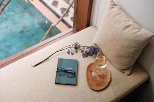 a table with a book and glasses on a window at Munno Villa in Canggu