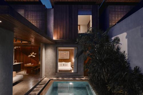 a house with a pool in the middle of a room at Munno Villa in Canggu
