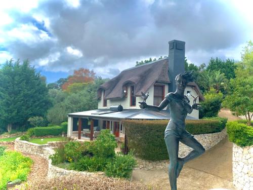 uma estátua de uma mulher em pé em frente a uma casa em The Guardian Hermanus Luxury Self-Catering Hemel en Aarde Valley em Hermanus