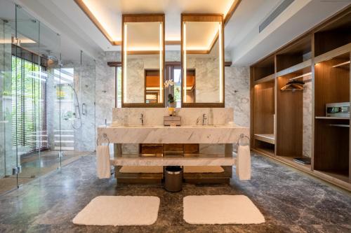 a bathroom with a large sink and a mirror at The Banjaran Hotsprings Retreat in Ipoh
