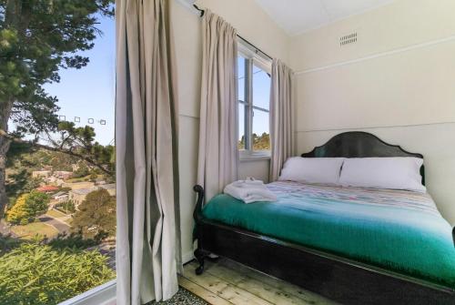 1 dormitorio con cama y ventana grande en Carinya Cottage en Katoomba