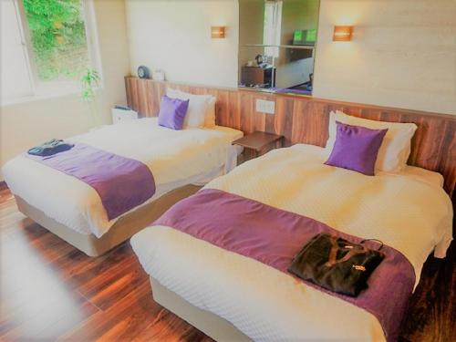 um quarto de hotel com duas camas e um sofá em LiVEMAX RESORT Izu Shimoda em Shimoda