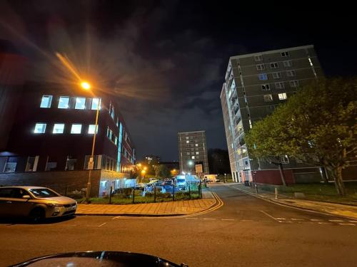a city street at night with buildings and a car at Xtra large 2 bedroom LondonFlat in Woolwich
