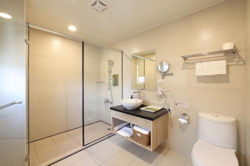 花蓮市的住宿－TC慢旅 花蓮忠孝館，浴室配有卫生间、盥洗盆和淋浴。