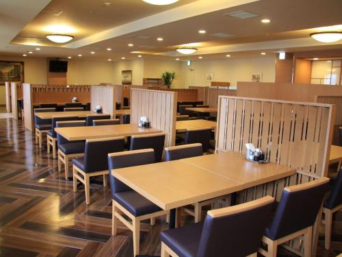 a dining room with wooden tables and chairs at Hotel Route-Inn Sapporo Chuo in Sapporo