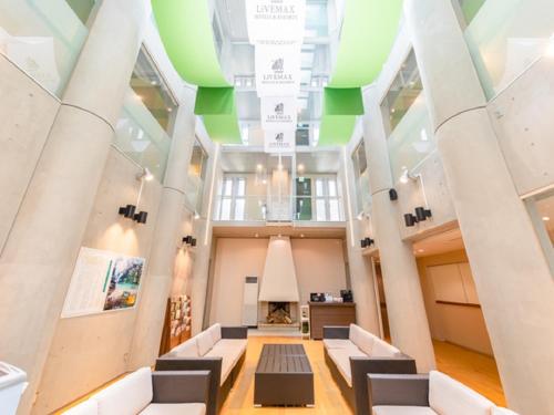 a lobby of a building with white and green ceilings at LiVEMAX RESORT Kusatsu Onsen in Kusatsu