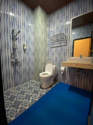 uma casa de banho com um WC, um lavatório e um espelho. em Christika Homestay em Labuan Bajo