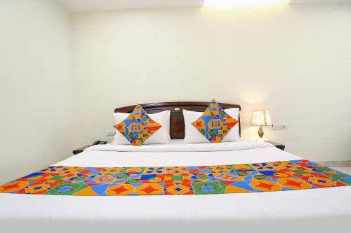 a bedroom with a bed with a colorful quilt on it at FabHotel F9 NSP in New Delhi