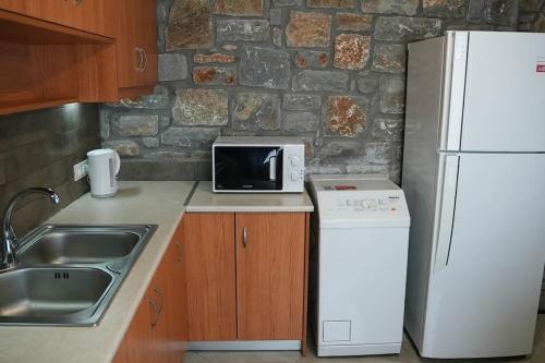 a kitchen with a sink and a white refrigerator at Mountain House Perampela in Nofaliás