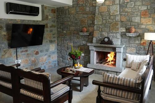 a living room with a stone wall with a fireplace at Mountain House Perampela in Nofaliás
