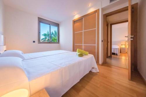 ein weißes Schlafzimmer mit einem großen Bett und einem Fenster in der Unterkunft 06 LUXURY MARINA 3 BEDROOMS in Ibiza-Stadt