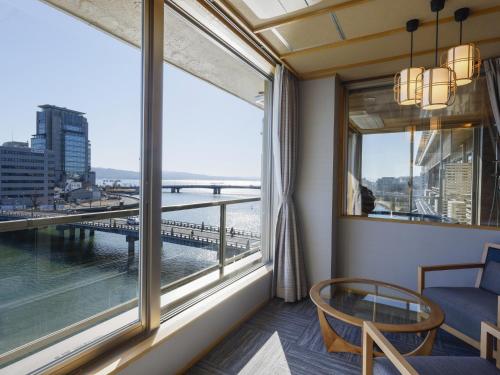 a room with a balcony with a view of a bridge at Ohashikan in Matsue