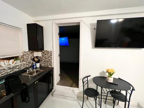 una cucina con tavolo e televisore appeso a un muro di Miami Gardens Comfort Suite by Hard Rock Stadium a Miami Gardens