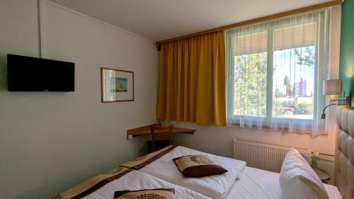a hotel room with a bed and a window at Acron-Hotel Quedlinburg in Quedlinburg