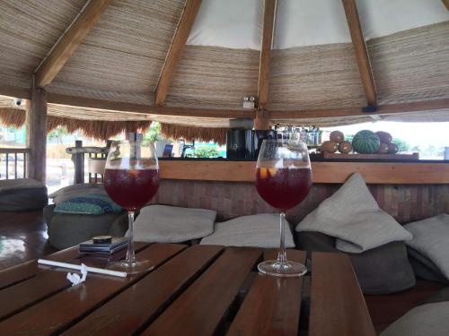 two glasses of wine sitting on a wooden table at 5 Min Walk To Famous Blue Water Resort And Tourist Area in Maribago