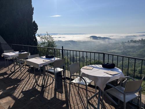 een rij tafels en stoelen op een balkon met uitzicht bij Terra d'Ombra Bed&Breakfast in San Gimignano