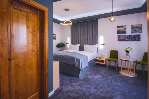 um quarto de hotel com uma cama, uma mesa e cadeiras em Rabbit Hole Superior Extension em Sibiu