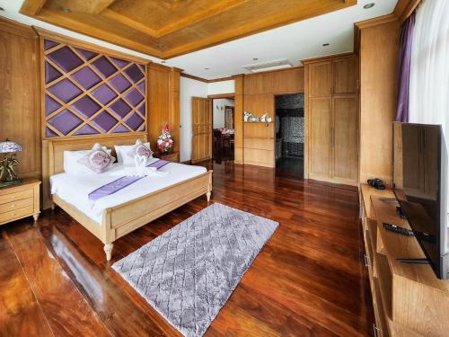 a large bedroom with a bed and a television at The Sand Beach Pattaya in Na Jomtien