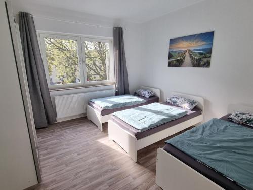 a room with two beds and a window at Viktoria's Appartment in OB-Mitte in Oberhausen