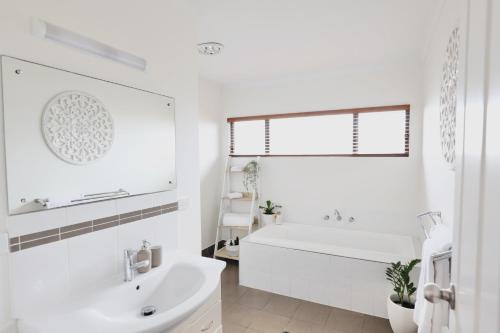 a white bathroom with a tub and a sink at Two Rivers - Harriet in Kingscote