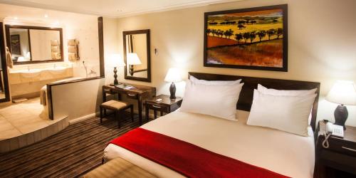 a hotel room with a bed and a bathroom at The Caledon Hotel and Spa in Caledon