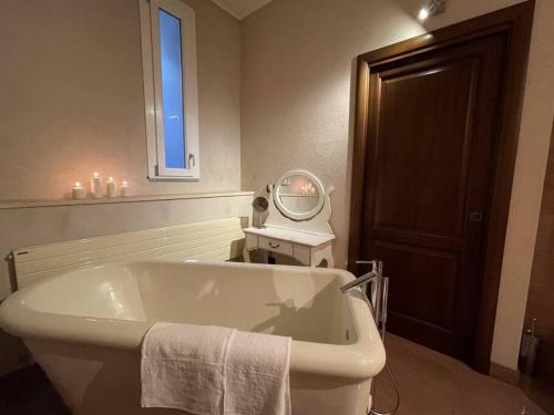 ein Badezimmer mit einer Badewanne, einem Spiegel und einem Waschbecken in der Unterkunft Fornace Garitta in Albissola Marina
