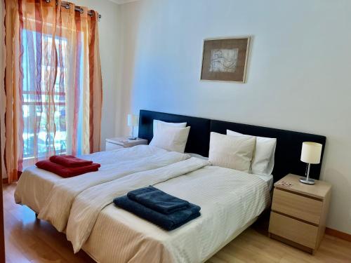 ein Schlafzimmer mit einem großen Bett mit zwei Handtüchern darauf in der Unterkunft Olhão Marina Village in Olhão