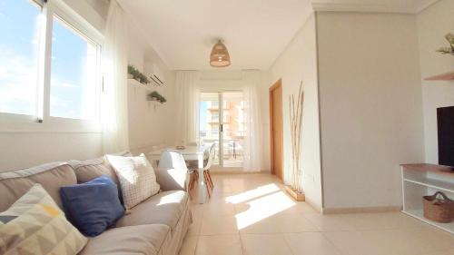 ein Wohnzimmer mit einem Sofa und einem Tisch in der Unterkunft Ayf 3 habitaciones moderno 1ª linea de playa in Oropesa del Mar